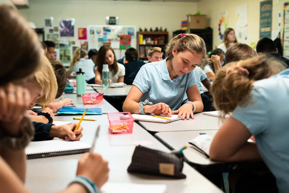 Students writing at classroom desks at ACA