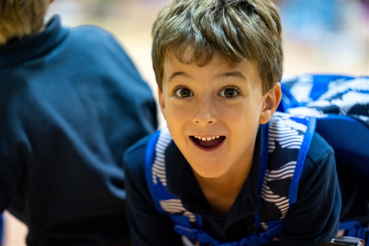 Smiling child wearing a backpack at ACA